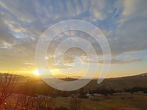 Sunrise or sunset over the hills and meadow.