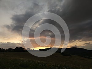 Sunrise or sunset over the hills and meadow.