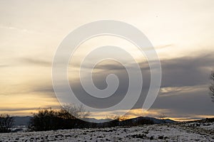 Sunrise or sunset over the hills and meadow.