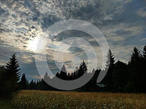 Sunrise or sunset over the hills and meadow.