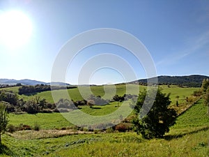 Sunrise or sunset over the hills and meadow.