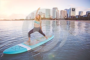 Sunrise SUP Yoga practice in Waikiki warrior pose