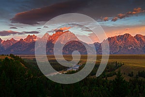 Sunrise of The Tetons tower over the Snake river