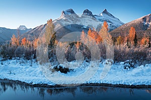 Sunrise of the Three Sisters and the Bow River from Canmore near Banff National Park. First snow in Canadian Rockies.