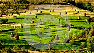 Sunrise in the Transylvania county Romania with fields of haystack