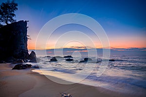 Sunrise at tropical beach against golden sky and cloud balckground