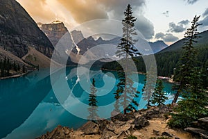 Sunrise with turquoise waters of the Moraine lake with sin lit rocky mountains in Banff National Park of Canada in