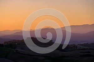 Sunrise in the typical Tuscan hills with cypresses, vineyards and house, Tuscany, Volterra, Italy