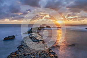 Sunrise on urbanova beach (agua amarga) between rocks. In urbanova, Elche