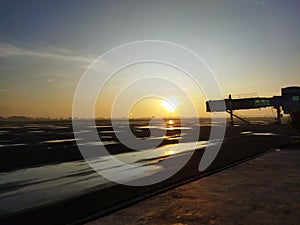sunrise view with aerobridge silhouette at airport