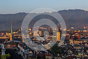 Sunrise view on churches, roofs and Uetliberg of Zurich city