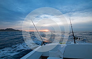 Sunrise view of fishing rod on charter fishing boat on the Pacific side of Cabo San Lucas in Baja California Mexico