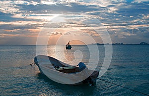 Sunrise View of Mexican Fishing Boat and ponga / skiff in Puerto Juarez Harbor of Cancun Bay photo