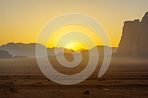 Sunrise view of sands and sandstone cliffs, in Wadi Rum