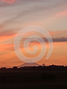 sunrise with views of a mountain in a cool countryside