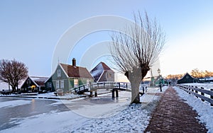 sunrise at the windmill village Zaanse Schans during winter with snow landscape in the Netherlands
