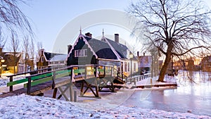 sunrise at the windmill village Zaanse Schans during winter with snow landscape in the Netherlands