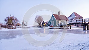 sunrise at the windmill village Zaanse Schans during winter with snow landscape in the Netherlands
