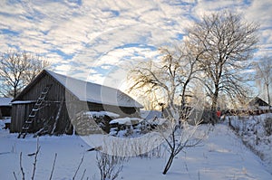 Sunrise in winter village covered snow and ice
