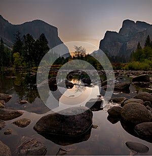 Sunrise at Yosemite Valley Viewpoint. Rocks in river foreground.