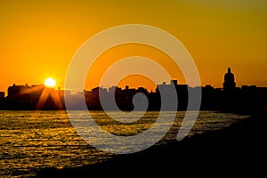 Sunrises over La Malecon, the dramatic sea wall protecting Havana, Cuba photo