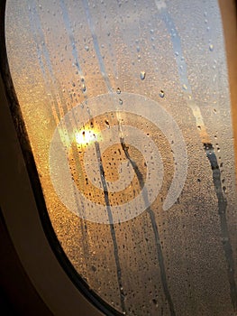 Sunrising from airplane windown with condensation in the early morning