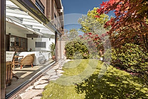 Sunroom with open sliding doors with wooden and wicker furniture inside