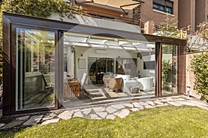 Sunroom with wide open sliding doors with wooden and wicker