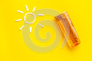 Sunscreen in bottle flatlay with sun made of white cream