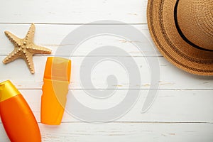 Sunscreen bottle with hat and shells on white background. Cosmetics for safe sunburn. Top view, flatlay. Sun protection cream with