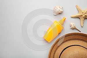 Sunscreen bottle with other accessories on grey background. Cosmetics for safe sunburn. Top view, flatlay. Sun protection cream