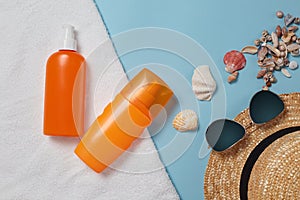 Sunscreen bottle,  sun hat, cream, lotion bottle, various sunscreens and seashells on a blue background. summer. vacation. Sun pro