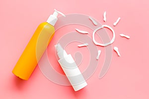 Sunscreen in bottles flatlay with sun made of white cream