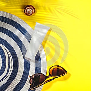 Sunscreen. Hat sunglasses and protection cream spf on yellow background