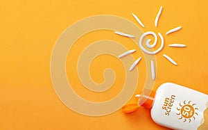 Sunscreen on orange background. Plastic bottle of sun protection and white sun-shaped cream