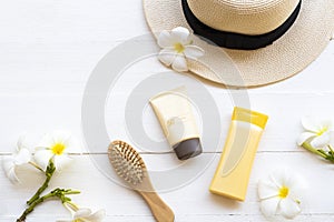 Sunscreen spf50 cosmetics beauty makeup for skin face with body lotion, comb, hat and flower frangipani of lifestyle woman relax