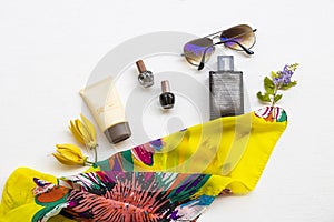 Sunscreen spf50, perfume, yellow scarf, sunglasses and nail polish accessories of lifestyle woman