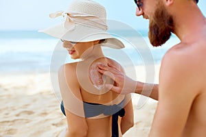 Sunscreen Sun Drawing Lotion on Suntan on Tanned Shoulder. Man Applying Protective Sun Cream on Woman Female Skin.