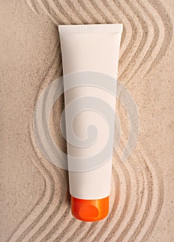 Sunscreen tube mockup. A tube of cream on the sand. SPF cream. The concept of UV protection