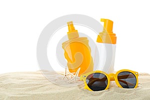 Sunscreens with starfish and sunglasses on clear sea sand isolated on white background