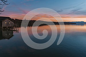 Sunset above a beautiful lake near munich in germany with mountains in the background