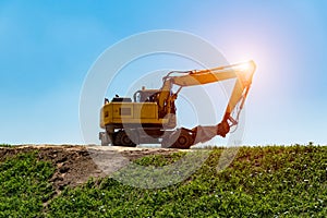 Sunset above excavator working on the construction site