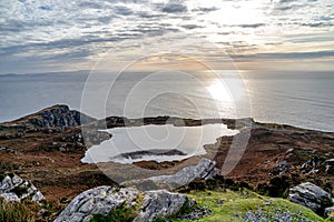Sunset above the lake at Slieve League Cliffs which are among the highest sea cliffs in Europe rising 1972 feet above