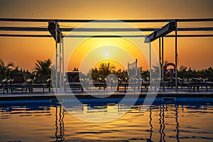 Sunset above a swimming pool, Atlantic Ocean and a beach in Senegal, Africa