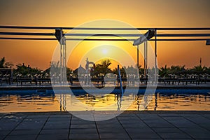 Sunset above a swimming pool, Atlantic Ocean and a beach in Senegal, Africa