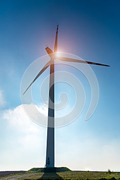 Sunset above windmill on the field