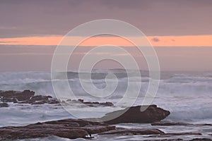 Sunset across rough seas and cloudy skies