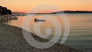 Sunset on the Adriatic Sea in Croatia, Kastel Luksic. View from the beach to the sea. Split city, mountains and yacht.