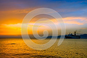 Sunset on Aegean sea with cruise ship silhouette