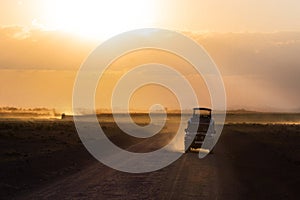 Sunset in african savannah, silhouettes of safari car, Africa, Kenya, Amboseli national park